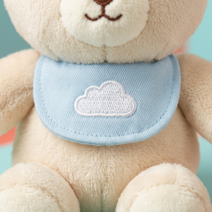 Detail of blue bib with embroidered white cloud