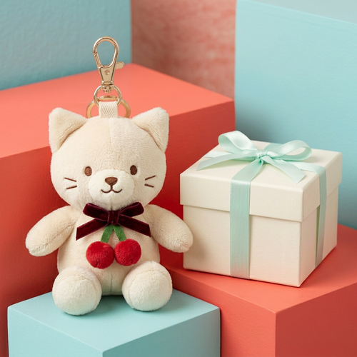 Cherry Mew cream cat charm beside unbranded gift box