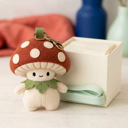 Mushroom Sprite with attached clasp beside unbranded open ivory gift box